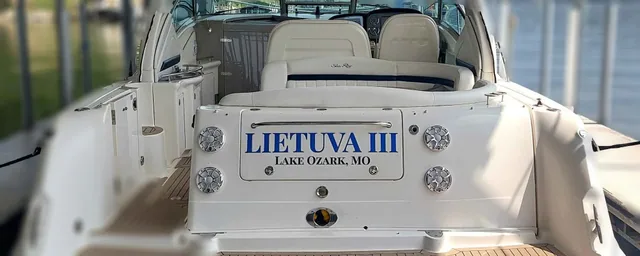 Blue name lettering on the stern of a white boat.