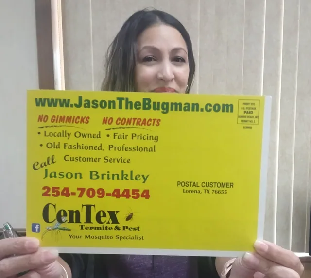 A yellow yard sign with contact details, held up for the camera.