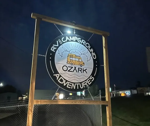 A round campground sign lit at night.