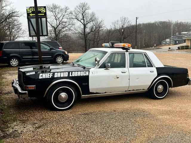 A classic black and white patrol car with police graphics.