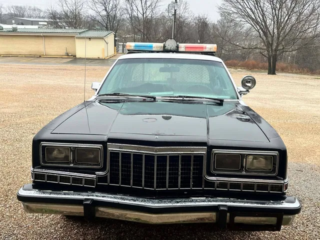 A classic black and white patrol car, seen head on.