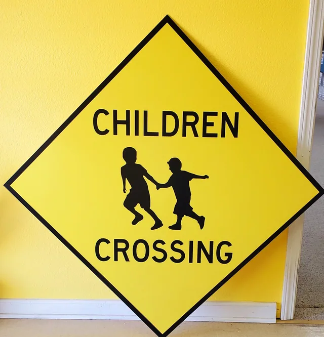 A yellow diamond children crossing sign.