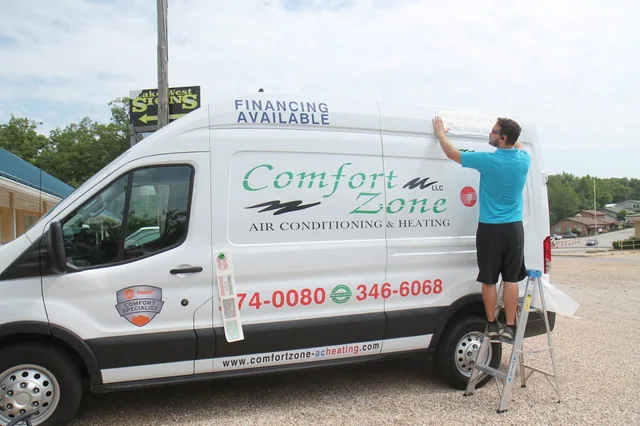 Lettering being fitted to a white van.