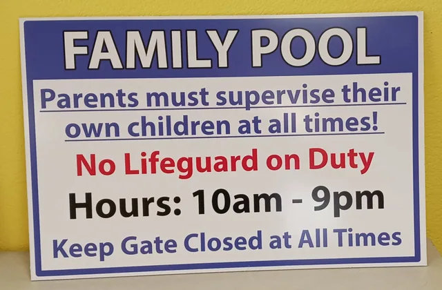 A family pool sign with blue and red lettering.