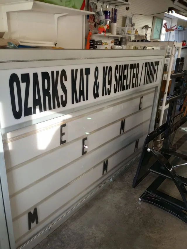 Black lettering for an animal shelter on a white panel.