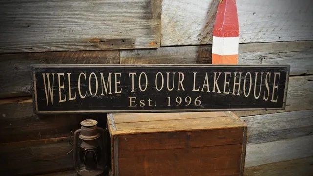 A wooden welcome sign with white lettering.