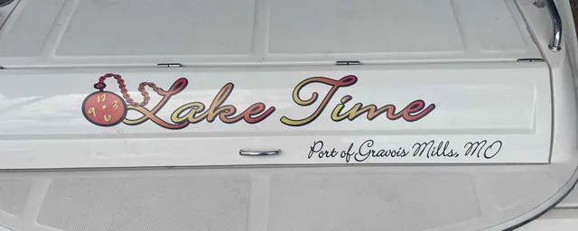 Script name lettering on the stern of a white boat.