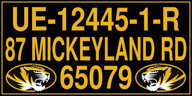 A black dock address sign with gold lettering and tiger graphics.