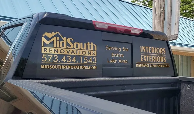 Rear window graphics with a logo and phone number on a pickup.