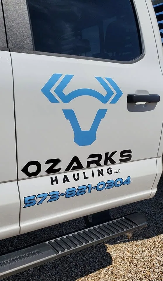 Blue door lettering and a logo on a white pickup.