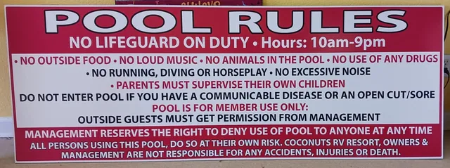 A pool rules sign with a red heading and small lettering.