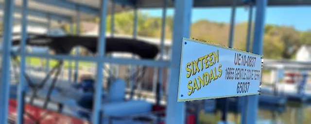 A blue and yellow address sign attached to dock railings.