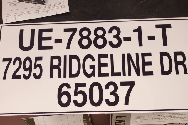 A white dock address sign with black lettering.