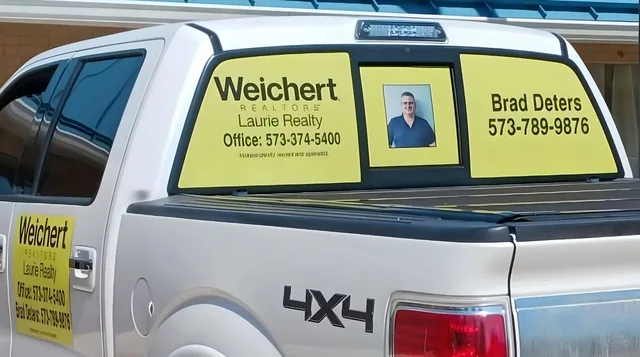 Rear window graphics with a logo and contact details on a pickup.