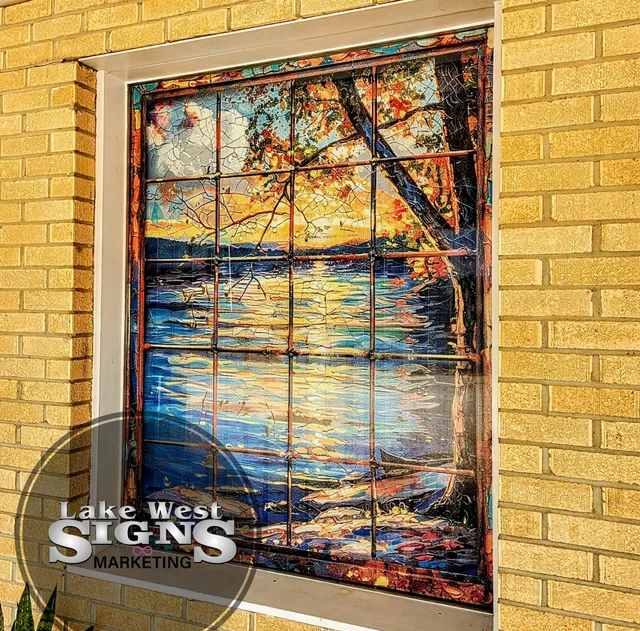 A full-color window graphic of a lake scene on a brick building.
